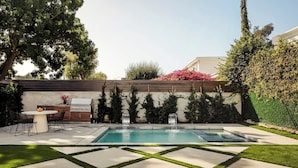 A backyard with a swimming pool, a barbecue area, and a dining table. - Tilden House | Designer Pool Home in West LA (Los Angeles)