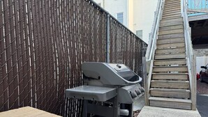 Grilli, jossa on pöytä ja puinen portaikko.