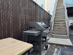 Ein Grill mit Tisch und einer Holztreppe.