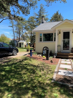 A small single-story house with a front porch, a mailbox, and a paved driveway.
