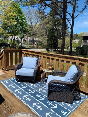 A deck with wicker furniture, a patterned rug, and a view of the neighborhood.