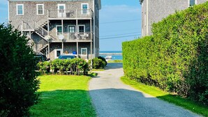 A two-story building with a red roof, a balcony, and a view of the sea. - Historic 7-bedroom home in the heart of downtown in private setting,Pet friendly (New Shoreham)