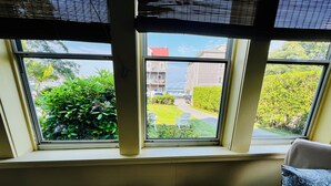 A room with a large window, a glass table, and a chair. - Historic 7-bedroom home in the heart of downtown in private setting,Pet friendly (New Shoreham)