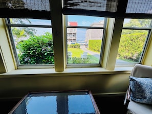 A room with a large window, a glass table, and a chair. - Historic 7-bedroom home in the heart of downtown in private setting,Pet friendly (New Shoreham)