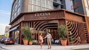 A modern building with a prominent 'CUCINA' sign, large windows, and a curved entrance. - 1BR + Balcony | Skyline Spa | Walk to Wynwood Walls (Miami)