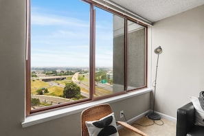 Una habitación con un ventanal grande que da a una autopista y al paisaje urbano.