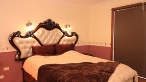 A bedroom with a tufted headboard, a ceiling fan, a bed with a brown blanket, and a window with a view. - Spacious Three-bedroom Holiday Home With the Entire House Exclusively Yours (Sanctuary Point)