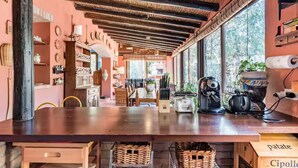 Uma cozinha com mesa de madeira, eletrodomésticos e janela com vista.