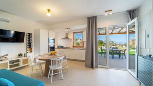 Una cocina moderna con comedor, ventanas amplias y una puerta corrediza de vidrio que da a un patio exterior.