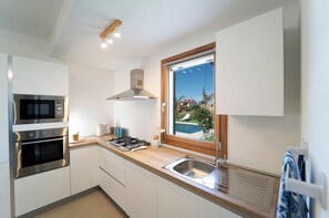 A modern kitchen with a built-in oven, microwave, and gas stove.