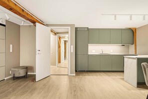 A modern kitchen with green cabinets, a white countertop, and a wooden ceiling. - 2BR Seaside Apartment - SKB17-R2 (Bergen)