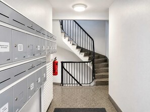 Una escalera con extintor, taquones metálicos y pasamanos.