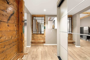 Un interior moderno con paneles de madera, una escalera y un televisor de pantalla plana.