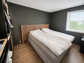 A bedroom with a bed, a wardrobe, and a window. - GL63 - 2BR Gronnlien - Free Parking (Bergen)