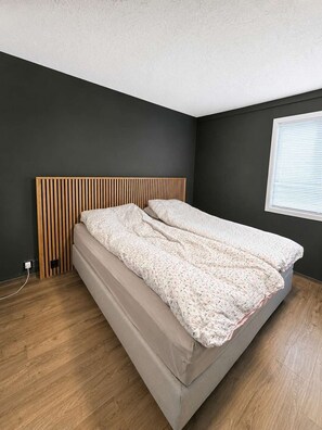 A bedroom with a bed, dark walls, a window, and a wooden floor. - GL63 - 2BR Gronnlien - Free Parking (Bergen)