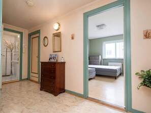 Ein Schlafzimmer mit Bett, Schminktisch, Spiegel und Fenster.
