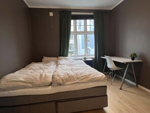 Una camera da letto con un letto, una scrivania e una sedia.