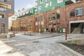 A modern building with a brick facade, large windows, and a sign for 'KIWI' on the ground floor. - MK38 2BR Cozy Apartment Bergen (Bergen)