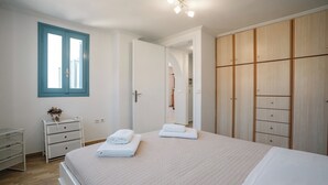 Una camera da letto con un letto, una cassettiera, un armadio e una finestra.