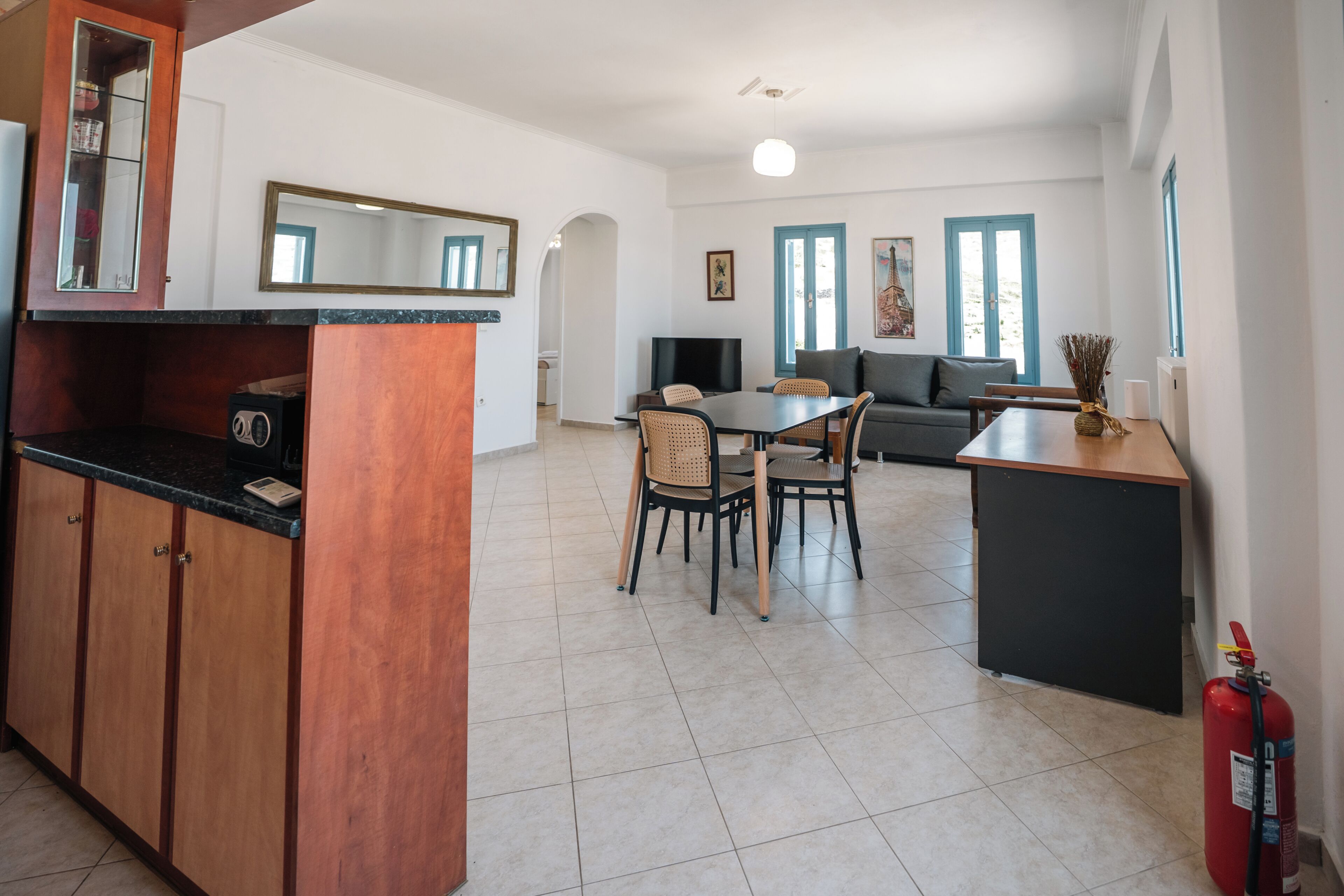 Una cocina moderna con comedor, sofá y extintor.