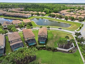 Un quartier résidentiel avec des maisons, une piscine et un étang.