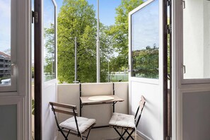 A corner balcony with a table and two chairs, a view of trees and a tennis court. - 5BR 2Bath Frogner - Parking - Vigelandsparken (Oslo)