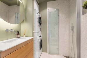 A modern bathroom with a large mirror, a washing machine, a glass shower enclosure, and a wooden vanity. - 5BR 2Bath Frogner - Parking - Vigelandsparken (Oslo)