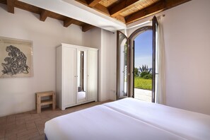A bedroom with a large bed, a wardrobe, a small stool, and a painting on the wall. - Apartment Agave with Lake View (Bardolino)