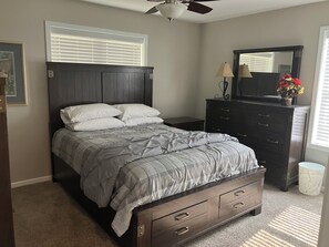A bedroom with a bed, dresser, nightstand, and a ceiling fan. - Peaceful 3 bedroom handicapped accessible house with AC in charming Hamilton. (Hamilton)