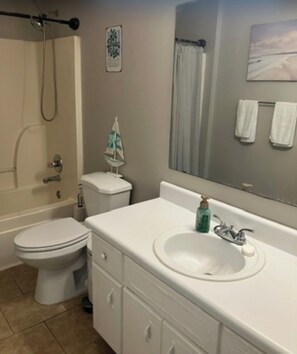 A bathroom with a toilet, sink, and shower. - Your Getaway Awaits (Pensacola)