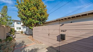 A residential area with a wooden fence, a mailbox, and a clear sky. - Cozy Pacific Beach 2BR Patio Fire Pit (San Diego)