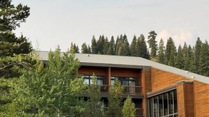A multi-story building with a wooden facade, large windows, and a balcony. - Ski-in, Chill-out Tahoe Donner Condo (Truckee)
