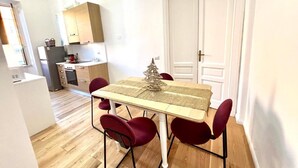 Eine kleine Küche mit Esstisch, Stühlen und einem kleinen Weihnachtsbaum.