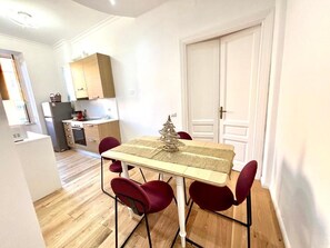 A compact kitchen with a dining table, chairs, and a small Christmas tree. - Cozy apartment in the Vatican district (Roma)