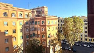 Un edificio a più piani con un cortile interno, auto parcheggiate e alberi.