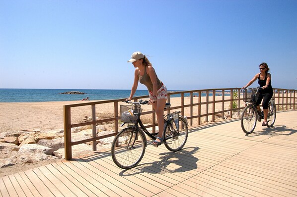 A wooden boardwalk by the beach with two bicycles. - Apartment Panoramic 23 by Parc Mont-roig (Miami Playa)