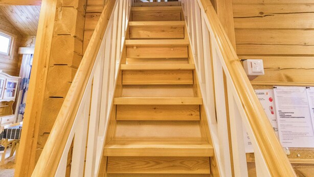 A wooden staircase with white railings leading to a higher floor.