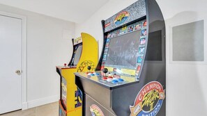 Deux bornes d’arcade dans une pièce aux murs blancs et à la porte fermée.