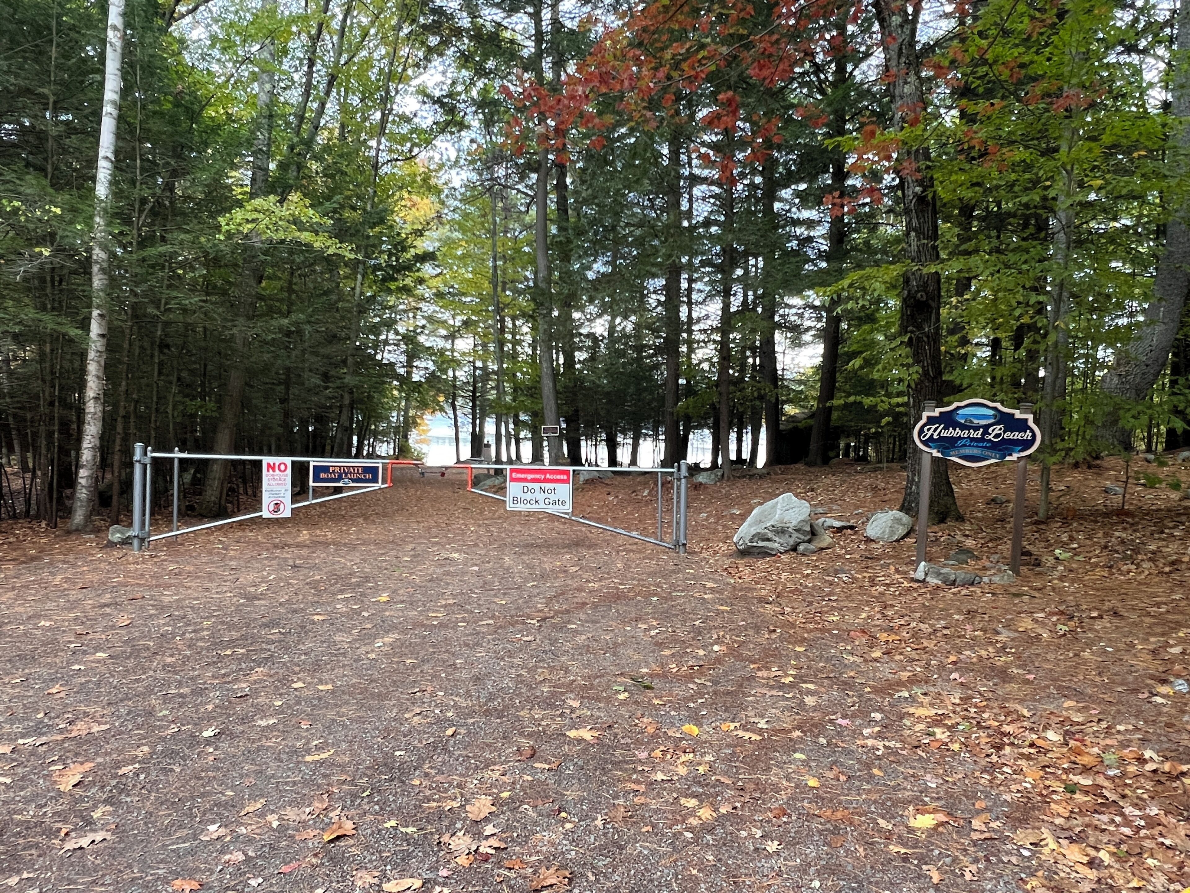 Una entrada cerrada con un cartel que indica 'Hubbard Beach' y 'Acceso de Emergencia', junto con un letrero que dice 'No obstruir la entrada'.
