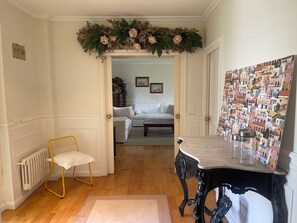 A room with a white radiator, a yellow chair, a table with metal containers, and a wall with a patterned wallpaper. - Casa Sierrapando - by Wehomes (Torrelavega)