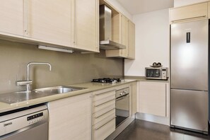 Een moderne keuken met roestvrijstalen apparatuur, een vaatwasser en een magnetron.