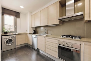 Een moderne keuken met roestvrijstalen apparatuur, houten keukenkastjes en een inbouwoven.