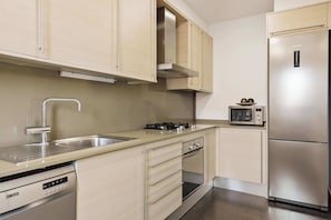 Una cucina moderna con elettrodomestici in acciaio inossidabile, lavastoviglie e forno a microonde.