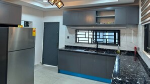 Una cocina moderna con una isla central, armarios empotrados y un refrigerador de acero inoxidable.