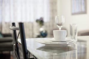Ein Esstisch mit weißen Tellern, einer Tasse und einem Glas.