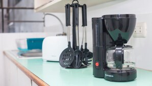 A kitchen with a coffee maker, spatulas, and a toaster. - Enjoyable 2-bedroom apartment with AC in Miraflores neighborhood (Miraflores)