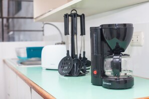 Eine Küche mit Kaffeemaschine, Pfannenwendern und Toaster.