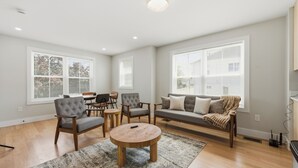 A spacious living room with a round coffee table, two sofas, and a dining area with chairs.