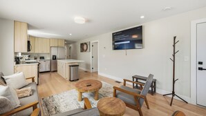 A modern apartment with a kitchen, dining area, and living room.