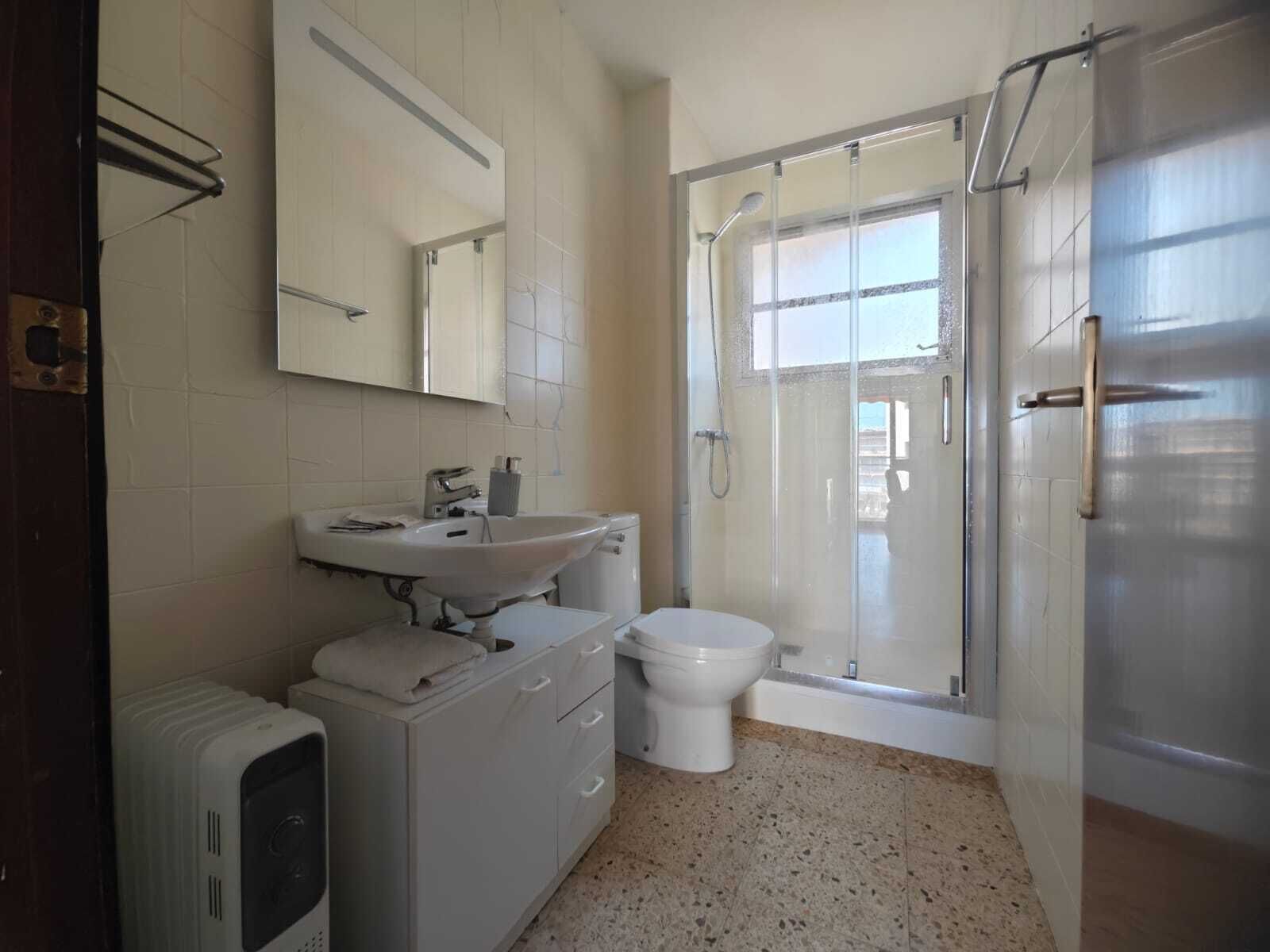Un baño con lavamanos, inodoro y ducha.